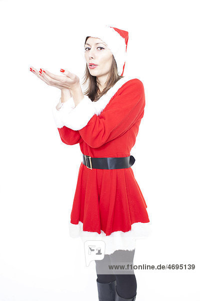 Frau im Weihnachtskostüm pustet auf Hände