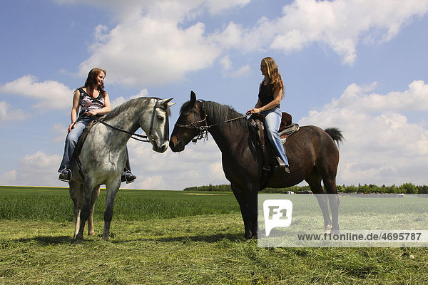 Zwei junge Frauen reiten auf ihren Pferden  Bayern  Deutschland  Europa
