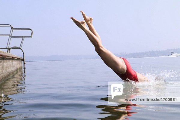 A woman diving into a lake.