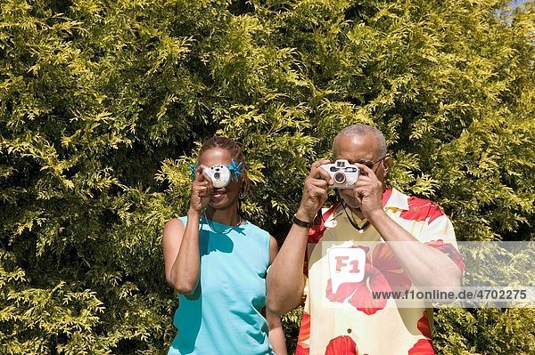Couple with cameras taking pictures