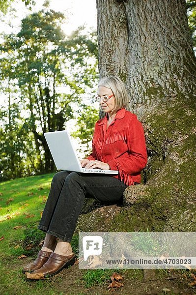 Woman with tree using laptop