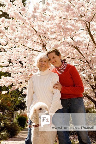 Portrait of woman with grown daughter and dog