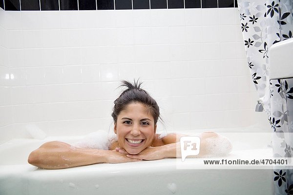 Woman resting on edge of bathtub