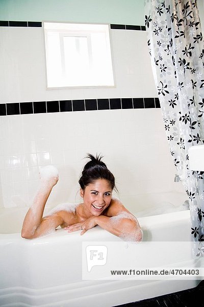 Woman playing with bubbles in bathtub