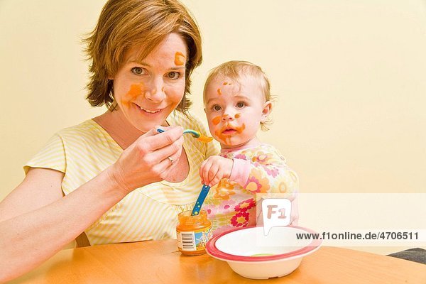 Mother feeding messy baby
