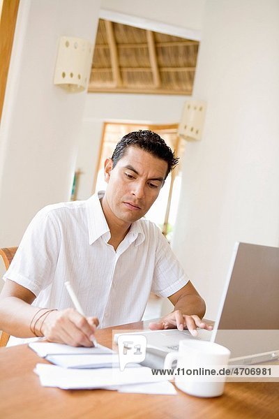 Man working on a laptop and preparing home finance budget
