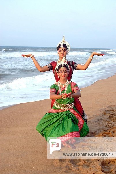 Dancers performing classical traditional odissi dance in front of bay of Bengal sea , Konarak , Orissa , India MR 736D, 736C