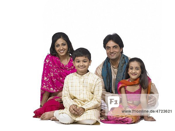 South Asian Indian family with father mother son and daughter sitting smiling and looking at camera MR 698 699 700 701