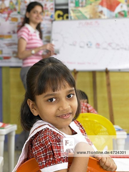 South Asian Indian girl looking behind in nursery school MR