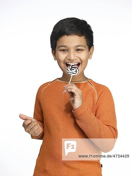 South Asian Indian boy licking lollipop in nursery school MR