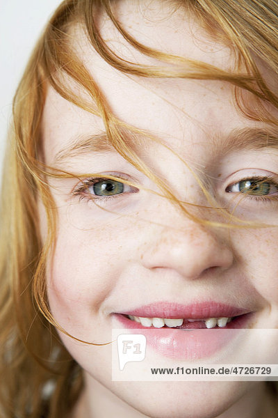 Portrait of a girl with red hair with a missing tooth