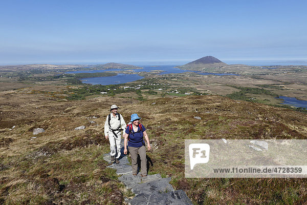 Hikers climbing to Diamond Hill  Connemara National Park  County Galway  Republic of Ireland  Europe