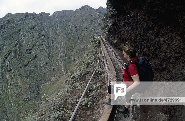 Female hiker standing in the irrigation channel of Barranco Seco  Punta del Hidalgo  Tenerife  Canary Islands  Spain  Europe