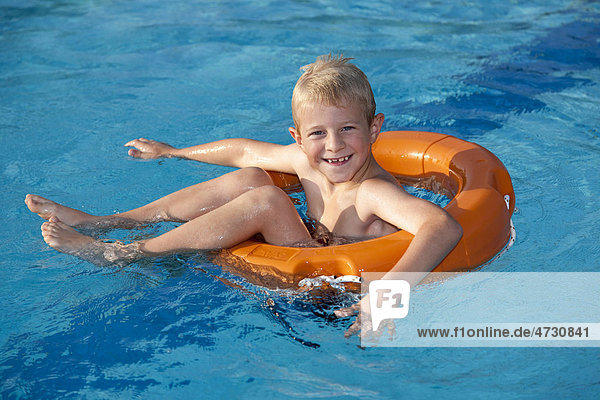 Boy 7 in a pool on a life ring
