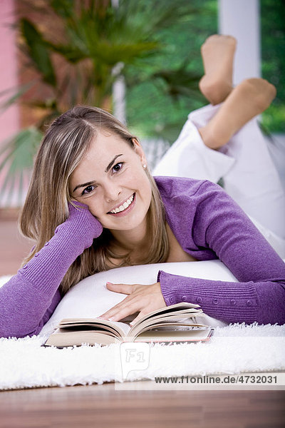 Young woman reading on the sofa in the living room