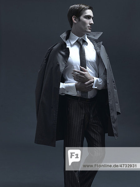 Modeaufnahme eines Mannes im Anzug und Mantel
