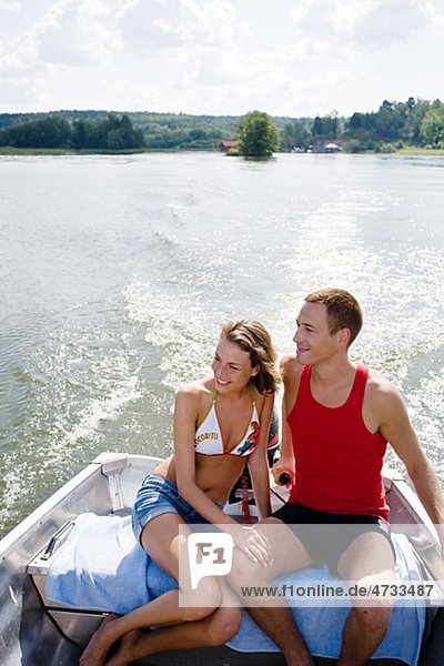 Young couple in motorboat on lake