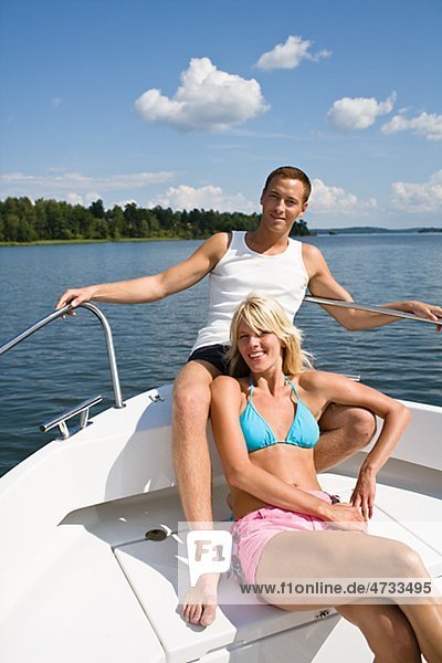 Young couple relaxing in yacht on lake