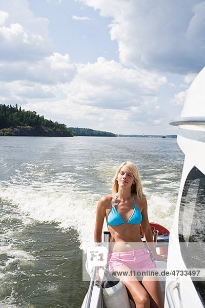 Young woman relaxing in motorboat on lake