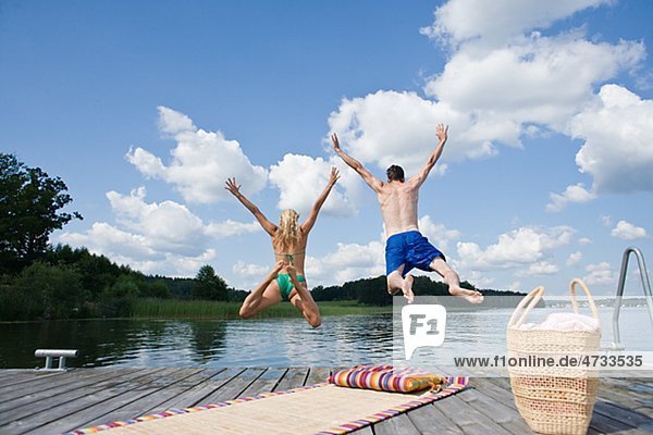 Couple jumping into lake