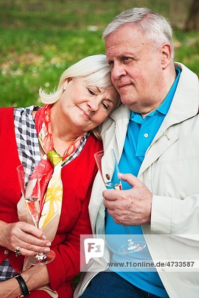 älteres Paar trinken Wein im park