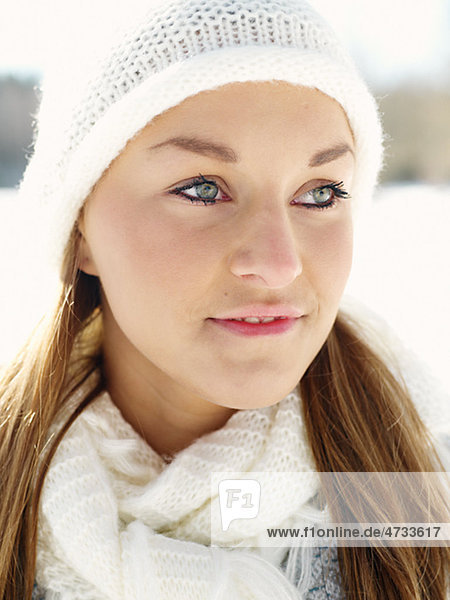 Portrait of young woman wearing white hat and white wooly scarf