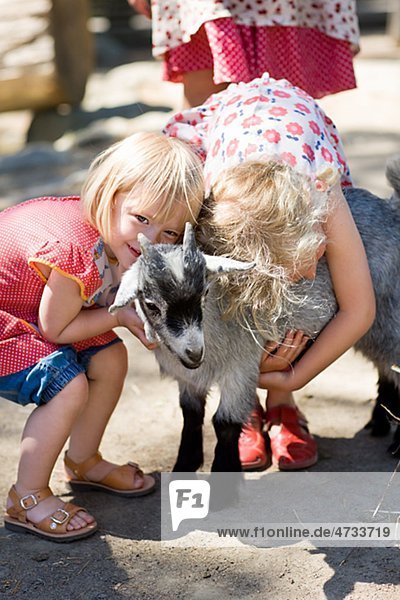Mädchen umarmen Ziege im zoo