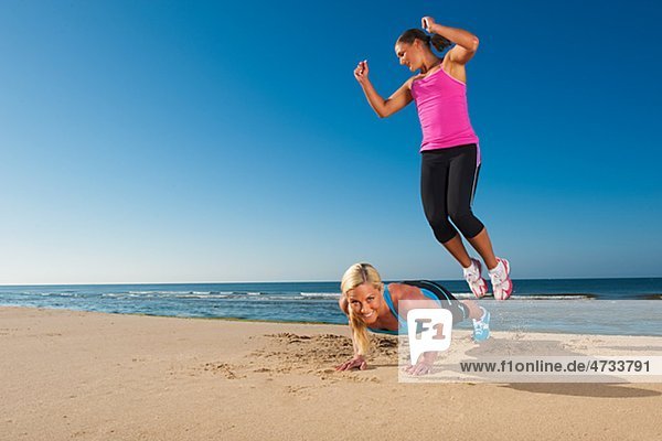 Zwei Frauen  sich fit halten am Strand