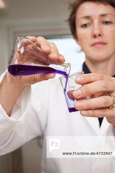 Wissenschaftler strömenden Flüssigkeit aus Becherglas