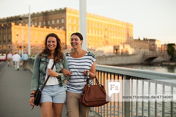 Zwei Frauen zu Fuß durch Brücke  lachen