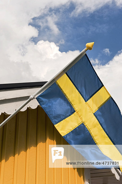 Schwedische Flagge vor gelber Wand  Schweden  Skandinavien  Europa