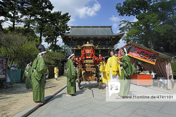Procession carrying a shrine to the shrine festival Matsuri  in the back the gatehouse of the Kintano Tenmango Shrine  Kyoto  Japan  Asia