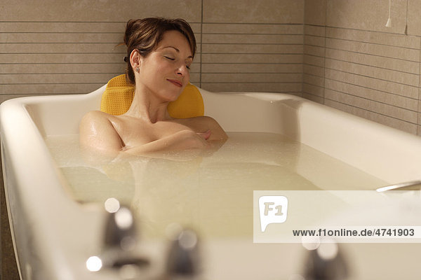 Woman  35  relaxing in a bathtub  Aphrodite bath with whey  Thalasso therapy in a spa resort