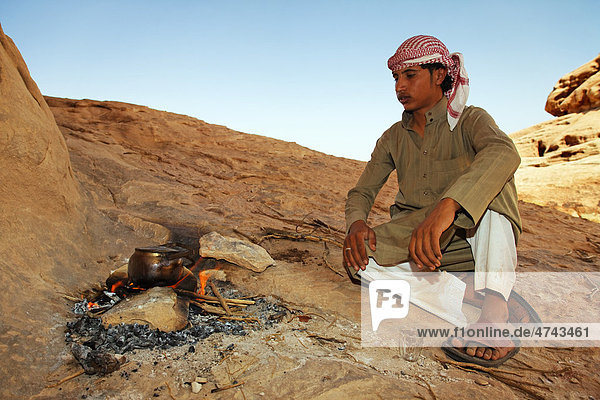 Young Bedouin seated beside a campfire in the desert  Wadi Rum  Hashemite Kingdom of Jordan  Middle East  Asia