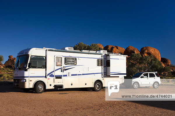 Campingbus mit angehängtem Auto am Campingplatz  Devils Marbles  Northern Territory  Australien