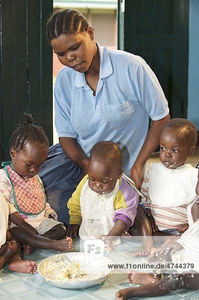 Kleinkinder und Kinderkrankenschwester beim Essen in einem Waisenhaus in der Nähe von Bukoba  Tansania  Afrika