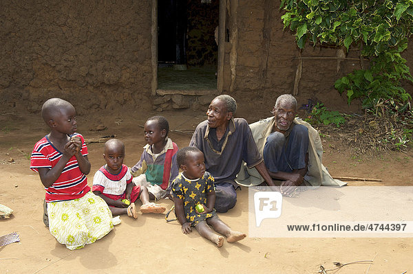 Familie vor einem traditionellen Lehmhaus in der Nähe von Bukoba  Tansania  Afrika