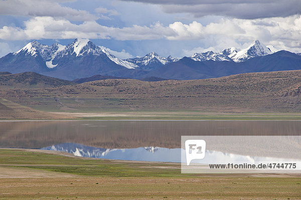 Hochalpiner Gebirgssee vor der Himalayakette entlang der südlichen Straße nach Westtibet  Tibet  Asien