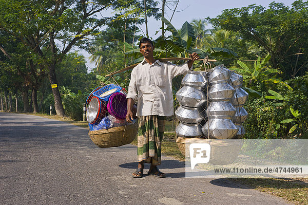 Man carrying many steel pots  Bangladesh  Asia
