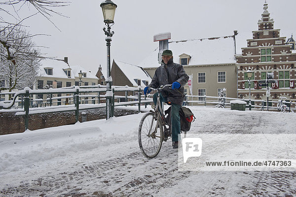 Radfahrer fährt auf vereister Straße in Amersfoort  Niederlande  Europa