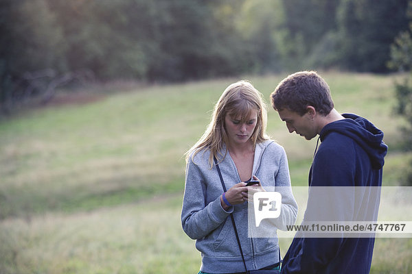 Young couple outdoors woman using a mobile phone