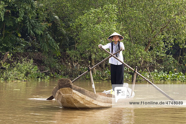 Eine Vietnamesien rudert durch einen Seitenarm des Mekong Flusses Mekongdelta Vietnam Südostasien