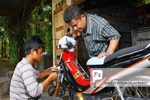 Jugendlicher in der Mechanikerlehre  Motorradreparatur  Berufsbildungswerk  Siantar  Sumatra  Indonesien  Asien