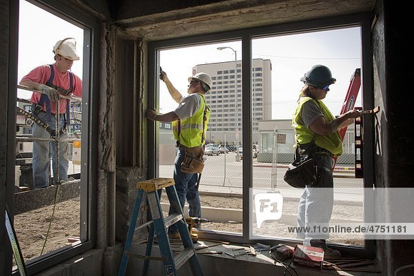 Tischler installieren Fensterrahmen bei der Renovierung von Wohnungen McKinley Tower (ehemals MacKay-Gebäude) in der Innenstadt von Anchorage  Südalaska  Sommer
