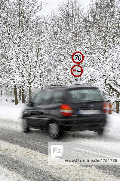 Verschneite Landstraße im Winter  Rutschgefahr  Gebotsschild  Verbotsschild  Auto  Wischeffekt