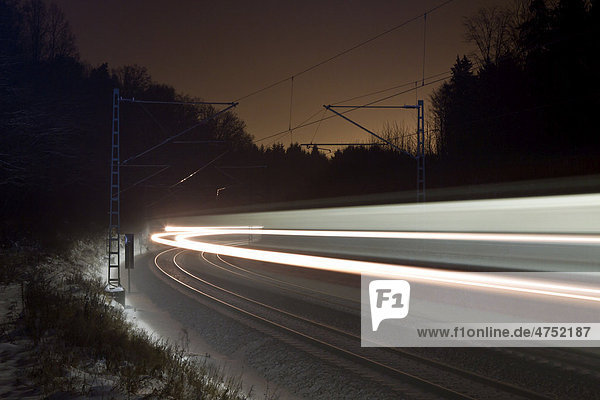 Light trace of a train in winter at night  Beimerstetten  Baden-Wuerttemberg  Germany  Europe