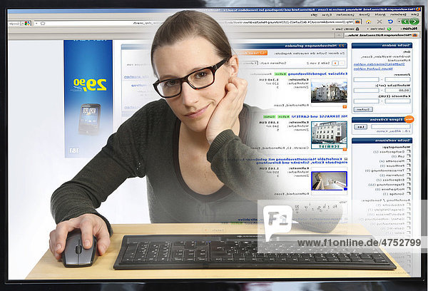 Junge Frau am Computer  surft im Internet  auf ImmobilienScout24.de  Blick aus dem Computer  Symbolbild