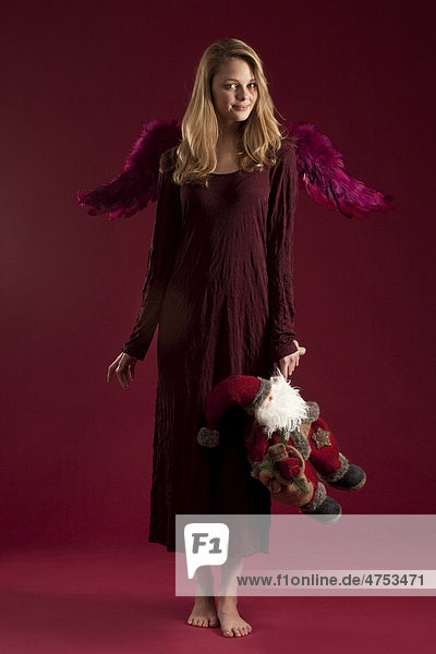 Blonde red-dressed angel with Santa Claus doll
