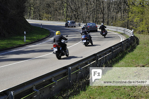 Motorcyclists in a curve on a country road with guard rail for protection  Eifel  Germany  Europe