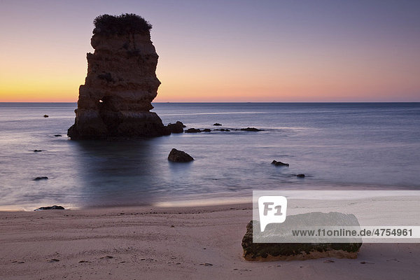 Hoher Felsen im Meer mit Strand im ersten Morgenrot  Praja dona Ana  Algarve  Portugal  Europa